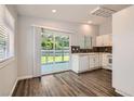 Eat-in kitchen with white cabinetry, stainless steel sink, and sliding doors leading to backyard at 318 Heather Dr, Henderson, NV 89002