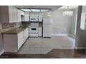 Well-lit kitchen with granite countertops, modern lighting, and tile floors at 4300 N Lamont St # 249, Las Vegas, NV 89115