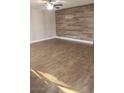 Spacious living room featuring wood flooring, ceiling fan, and modern accent wall at 4300 N Lamont St # 249, Las Vegas, NV 89115