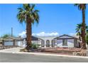 Inviting single-story home showcasing mature desert landscaping, and a two-car garage at 4461 Greenhill Dr, Las Vegas, NV 89121