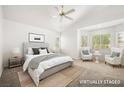 Calm bedroom with large bed, light gray carpet, white walls, and sitting area near bright windows at 4521 Crimson Leaf Dr, Las Vegas, NV 89130