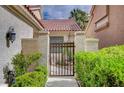 Charming private walkway leading to home through wrought iron gate and mature landscaping at 5112 Onion Creek Ln, Las Vegas, NV 89113