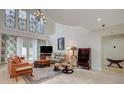 Spacious living room featuring high ceilings, elegant chandelier and tiled floors at 5112 Onion Creek Ln, Las Vegas, NV 89113