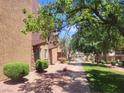 An exterior view of an apartment building with mature trees, green grass, and manicured shrubbery at 5188 River Glen Dr # 453, Las Vegas, NV 89103