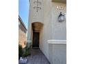 Close up of the front entrance featuring an arched entry and desert landscaping at 5550 Jinan St, Las Vegas, NV 89148