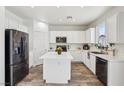 Bright kitchen featuring white cabinets, stainless steel appliances, a center island, and stylish flooring at 564 Lampshire Ln, Pahrump, NV 89060