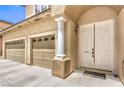 Inviting front entrance showcasing a double door, pillars and a view of the spacious two-car garage at 5862 Bluthe Bridge Ave, Las Vegas, NV 89141