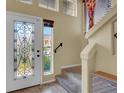 View of the home's foyer with decorative door, staircase, and tile floors at 6726 Glissando Ct, Las Vegas, NV 89139