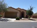 Inviting single-story house featuring a two-car garage and desert-style landscaping at 711 Golden Sedum Dr, Henderson, NV 89011