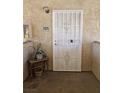 Exterior view of unit door number 2025 with a white security screen door and a small table with a plant at 7300 Pirates Cove Rd # 2025, Las Vegas, NV 89145