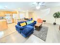 Open-concept living area with modern furnishings, breakfast bar and view of staircase and dining area at 7319 Burnt Umber St, Las Vegas, NV 89139
