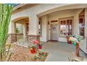 Close up of a charming home entrance, decorated with plants and a decorative wreath at 9142 Royal Monarch Ct, Las Vegas, NV 89147
