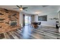 Open-concept dining area features a brick fireplace, modern lighting, and a glass door leading to the yard at 100 Huntly Rd, Las Vegas, NV 89145
