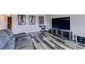 Comfortable living room featuring a gray couch, decorative guitar art, and entertainment center at 100 Huntly Rd, Las Vegas, NV 89145