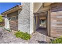 Modern home exterior showcasing a decorative stone accent wall, walkway, and lush landscaping at 10048 Copper Edge Rd, Las Vegas, NV 89148