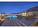 Stunning outdoor pool with lounge areas, inviting seating, and views of the city lights at dusk at 10048 Copper Edge Rd, Las Vegas, NV 89148