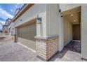 Close up of the exterior showing brick and stucco finish, tiled entry and two car garage at 10590 Dryades Ave, Las Vegas, NV 89166