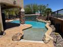 Inviting backyard pool with a rock waterfall feature and ample space for relaxation at 10601 Turquoise Valley Dr, Las Vegas, NV 89144