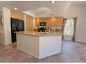 Bright kitchen boasts a large island with granite countertops, a black refrigerator and lots of storage at 1564 Silver Knoll Ave, Las Vegas, NV 89123