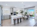 Bright, open kitchen with stainless steel appliances, an island with seating, and a dining area with backyard views at 180 Native Stone St, Las Vegas, NV 89138