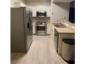 A kitchen featuring stainless steel appliances and bright white cabinetry and wood floors at 2151 Hussium Hills St # 207, Las Vegas, NV 89108