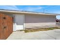 Side view of home shows exterior door and beige siding, needing some TLC at 2257 Colebrook St, Las Vegas, NV 89115