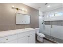 Modern bathroom featuring a glass shower, gray tile, and a large vanity with gold hardware at 2913 Hawksdale Dr, Las Vegas, NV 89134