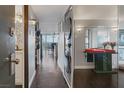 Hallway with wood floors, laundry closet, table, and mirror with a view to a dining room at 3111 Bel Air Dr # 16D, Las Vegas, NV 89109