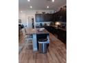 Modern kitchen featuring dark cabinets, granite countertops, a center island, and stainless steel appliances at 3862 E Summit Ave, Pahrump, NV 89061