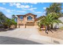 Beautiful two-story home with a three-car garage, front yard desert landscaping, and a welcoming facade at 395 Suzanne Peak Ct, Henderson, NV 89012