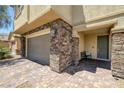 Beautiful home entrance featuring stone accents, a two-car garage, and a cozy porch at 4050 Midnight Crest Ave, North Las Vegas, NV 89031