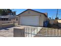 Exterior shot of home's one-car garage and driveway featuring a secure fence at 4690 E California Ave, Las Vegas, NV 89104