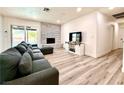 Bright living room with modern flooring, brick fireplace, sliding glass doors and a comfortable, neutral color palette at 4881 E Imperial Ave, Las Vegas, NV 89104