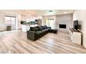 Open-concept living area featuring wood flooring, a brick fireplace, and an adjacent modern kitchen at 4881 E Imperial Ave, Las Vegas, NV 89104