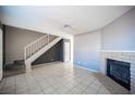 Spacious living room featuring tile flooring, a cozy fireplace, and a staircase at 5241 Janfred Ct # 18, Las Vegas, NV 89103