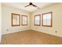 Bedroom with tile flooring, neutral walls, ceiling fan and three windows with wood shutters at 5380 Flowing Spring St, Las Vegas, NV 89122