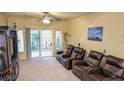 Cozy living room featuring three brown leather recliners facing a sliding glass door to the backyard at 6339 Sharp Rock Ct, Las Vegas, NV 89139