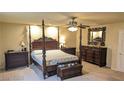 Beautiful main bedroom with a four-poster bed, carpet, and decorative mirror over dresser at 6339 Sharp Rock Ct, Las Vegas, NV 89139