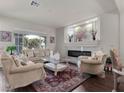 Elegant living room featuring a fireplace, decorative rug, and large windows offering ample natural light at 6465 Grande River Ct, Las Vegas, NV 89139