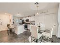 Open concept kitchen with white cabinets, an island with bar seating, and a dining area at 6835 Orange Horizon St, North Las Vegas, NV 89086