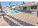 Backyard with a pristine pool, complemented by a covered patio and desert landscaping at 6842 Greengrove Dr, Las Vegas, NV 89103