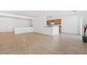 Open-concept living space with tile floors flowing into a kitchen area with a half-wall divider at 7448 Lintwhite St, North Las Vegas, NV 89084