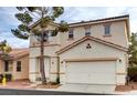 Two-story home with a two car garage, red tile roof, desert landscaping, and a tree in front at 971 Whispering Grove Ave, Las Vegas, NV 89123