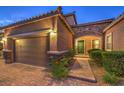 Home with stone details, attached garage, and green front door at 9760 Arch Canyon Ct, Las Vegas, NV 89149