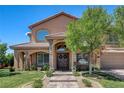 Beautiful home exterior featuring a meticulously maintained lawn, mature trees, and stately front entrance at 1182 Thomas Bay Cir, Logandale, NV 89021