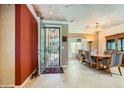Formal entryway with a wrought iron door, adjacent to a dining area with elegant chandelier at 2151 Bannerwood St, Henderson, NV 89044