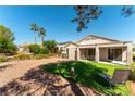 Private backyard oasis featuring lush green lawn, desert landscape, covered patio, and ample space for outdoor living at 2185 High Mesa Dr, Henderson, NV 89012