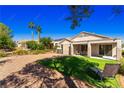 A spacious backyard featuring artificial grass, gravel landscaping, and a covered patio at 2185 High Mesa Dr, Henderson, NV 89012