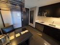Contemporary kitchenette featuring stainless steel appliances, sleek cabinetry, and a dining table at 2600 W Harmon Ave # 20034, Las Vegas, NV 89158