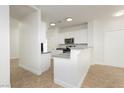 Open kitchen featuring white cabinets, stainless steel microwave, and gray counters at 3041 Gary Cooper St # 103, Las Vegas, NV 89122